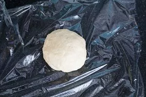 Teig zu einer Kugel formen und in Frischhaltefolie f&uuml;r zwei Stunden in den K&uuml;hlschrank packen