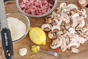 Schinken und Champignons schneiden, Knoblauch, Zitronenabrieb und Parmesan vorbereiten