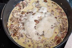 Sahne in die Pfanne geben und würzen