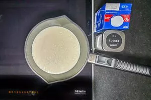 Milch und Zucker in einem kleinen Topf aufkochen