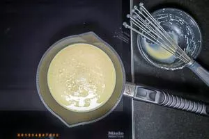 Ei-Sahne-Mischung in die kochende Milch einrühren