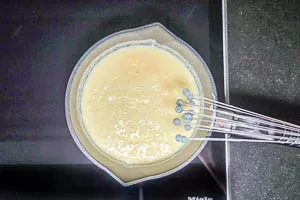 Vanillesoße mit einem Schneebesen bis zum Eindicken rühren