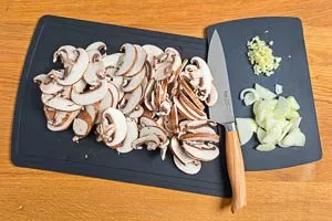 Champignons, Zwiebeln und Knoblauch klein schnippeln.