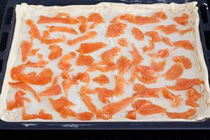 Räucherlachs in Stücke zupfen und den Blätterteig belegen