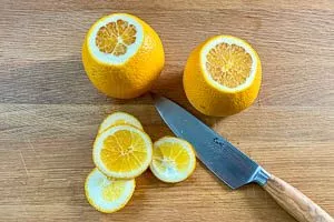 Die Enden der Orangen abschneiden.