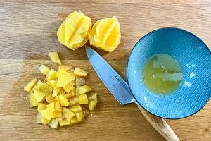 Saft auffangen und Orangenfilets klein schneiden.