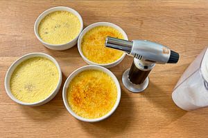 Zucker auf die Creme streuen und mit einem Brenner karamellisieren