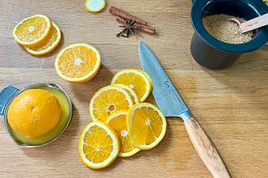 Orangen teilweise in Scheiben schneiden und auspressen