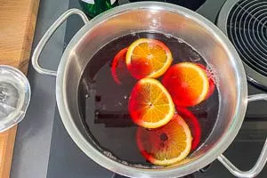 Orangenscheiben und Saft in den Topf geben