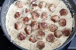 Hackbällchen in die Soße geben