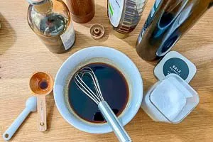 Balsamico-Essig, Honig, Olivenöl, Salz und schwarzer Pfeffer aus der Mühle als Marinade verrühren