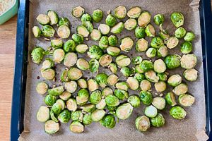 Rosenkohl auf einem Backblech mit Backpapier verteilen