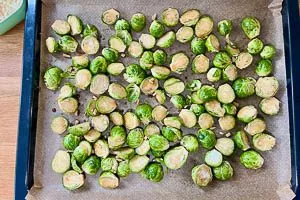 Rosenkohl auf einem Backblech mit Backpapier verteilen