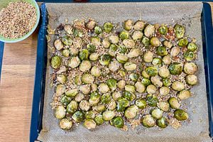 Nach dem Backen gehackte Haselnüsse auf dem Rosenkohl verteilen