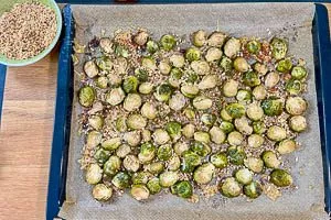 Nach dem Backen gehackte Haselnüsse auf dem Rosenkohl verteilen