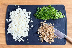 Feta, Frühlingszwiebeln und Walnüsse zerkleinern.