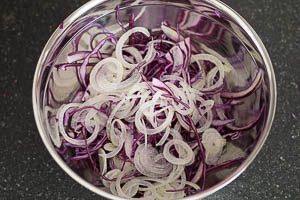 Rotkohl hobeln und Zwiebel in feine Streifen schneiden