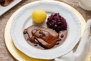 Sauerbraten warm mit Bratensoße, Kartoffelknödeln und Rotkohl servieren