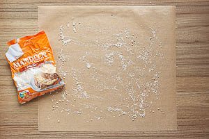 Backpapier mit gemahlenen Mandeln bestreuen.