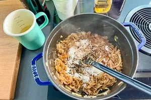 Zwiebeln mit Mehl vermengen und mit Wein, Essig und Sherry ablöschen.