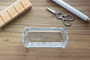 Kastenform mit Frischhaltefolie auskleiden, Butterkekse bereitstellen