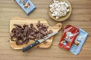 Zartbitter- und Vollmilch-Kuvertüre zerkleinern, Kokosfett in Würfel schneiden