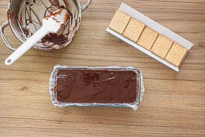 Kekse und Schokolade schichten, bis die Schokocreme verarbeitet ist und mit Schokolade abschließen