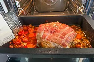 Mit Bratenfond den Krustenbraten angießen