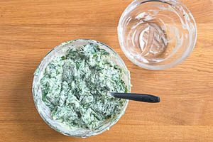Spinat zur gewürzten Frischkäsemischung hinzugeben