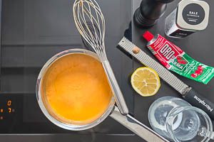 Tomatenmark, Gewürze und Milch zur Butter-Mehl-Mischung hinzugeben