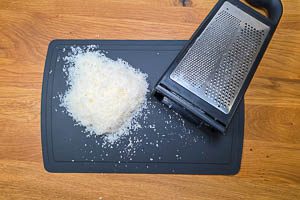 Parmesan auf einer Turmreibe frisch reiben