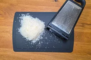 Parmesan auf einer Turmreibe frisch reiben