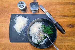 Spinat, geriebenen Käse und Gewürze in einer Schüssel vermengen