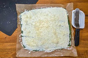 Frischkäse gleichmäßig auf der gestockten Spinat-Ei-Masse verteilen