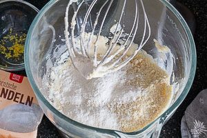 Trockene Zutaten und frischen Zitronenabrieb mit den restlichen Zutaten zum Teig vermengen