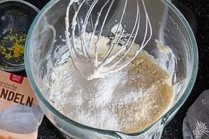 Trockene Zutaten und frischen Zitronenabrieb mit den restlichen Zutaten zum Teig vermengen