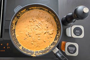Pilzrahmsoße mit Gewürzen wie Salz, Pfeffer und Cayennepfeffer abschmecken