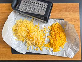 Edamer und Cheddar reiben.