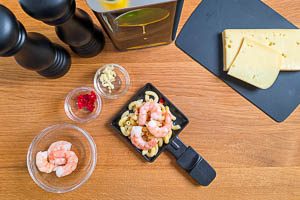 Nudeln vorbereiten und mit Käse und Garnelen toppen.