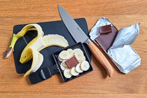 Banane schneiden, Schokolade zugeben und unter den Raclette-Grill stellen.