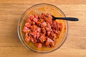 Fleisch mit Gewürzpaste vermengen.
