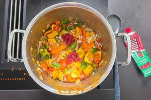 Tomatenmark in den Topf geben.