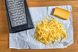 Käse mit einer Küchenreibe reiben