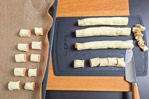 Teigränder entfernen und die Rollen in kleine Stücke schneiden