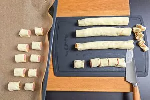 Teigränder entfernen und die Rollen in kleine Stücke schneiden