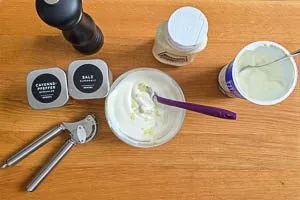 Soße aus gepresstem Knoblauch, Joghurt, Mayonnaise, Salz, Cayennepfeffer und schwarzem Pfeffer anrühren