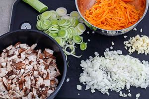Champignons, M&ouml;hren, Lauch, Zwiebeln und Knoblauch schneiden