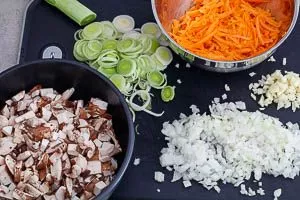 Champignons, M&ouml;hren, Lauch, Zwiebeln und Knoblauch schneiden