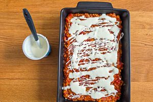 Schmand als letzte Schicht der Linsenlasagne einschichten