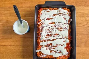Schmand als letzte Schicht der Linsenlasagne einschichten